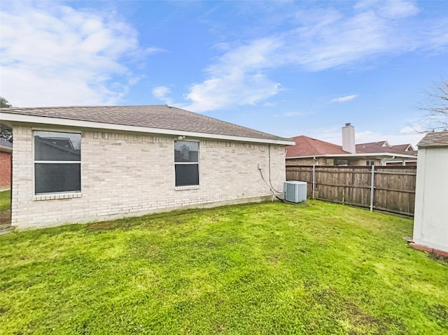 view of yard with fence and central AC