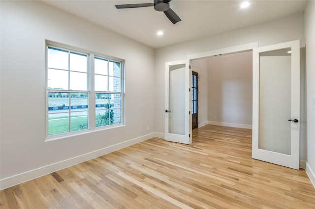 spare room featuring light wood-style floors, recessed lighting, baseboards, and french doors