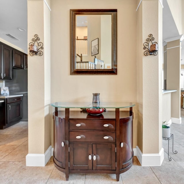 hall featuring ornate columns, visible vents, and baseboards