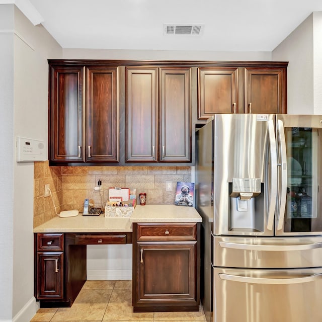 kitchen with visible vents, decorative backsplash, stainless steel fridge with ice dispenser, built in desk, and light tile patterned flooring