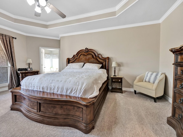 carpeted bedroom featuring baseboards, a tray ceiling, a ceiling fan, and ornamental molding