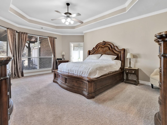 bedroom featuring ornamental molding, a tray ceiling, light carpet, and baseboards