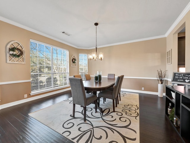 dining room featuring crown molding, visible vents, a chandelier, baseboards, and hardwood / wood-style flooring