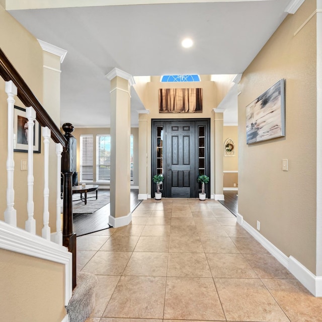 foyer with light tile patterned flooring, decorative columns, baseboards, and stairs