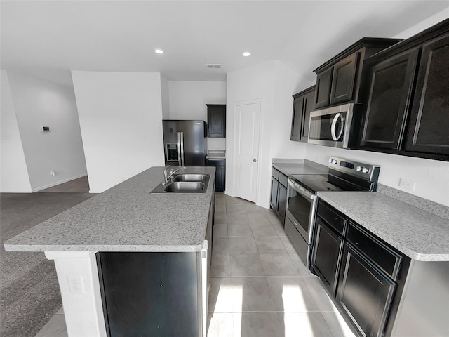 kitchen featuring recessed lighting, stainless steel appliances, a sink, visible vents, and an island with sink