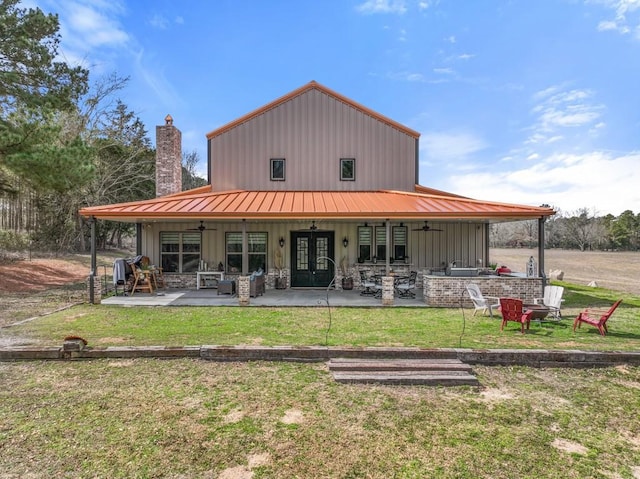 back of house featuring a ceiling fan, a patio, a standing seam roof, french doors, and board and batten siding