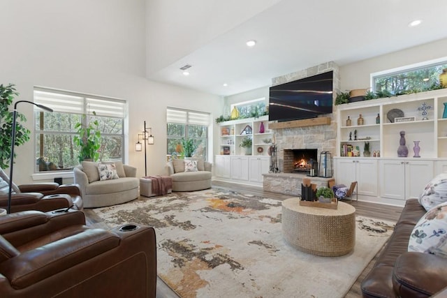 living area featuring a wealth of natural light, a fireplace, and wood finished floors