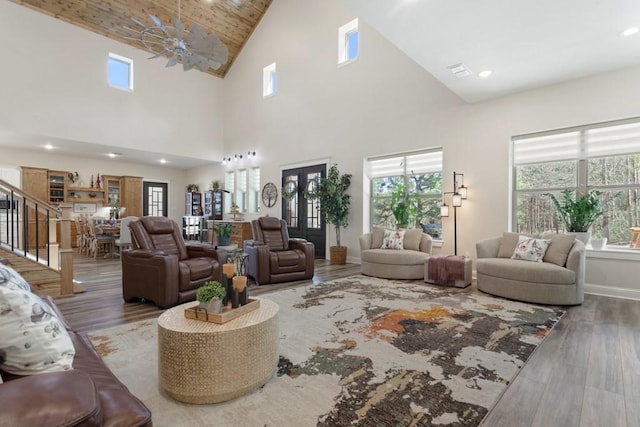 living area with stairs, recessed lighting, baseboards, and wood finished floors