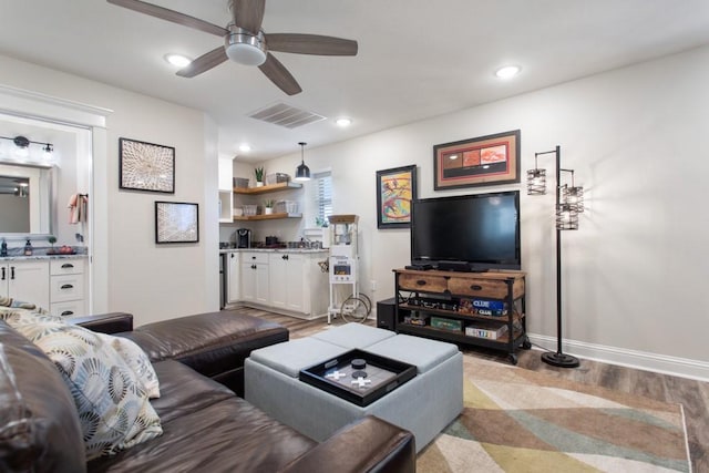 living room with recessed lighting, visible vents, a ceiling fan, light wood-type flooring, and baseboards