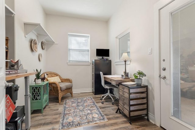 office space featuring baseboards and light wood-style floors