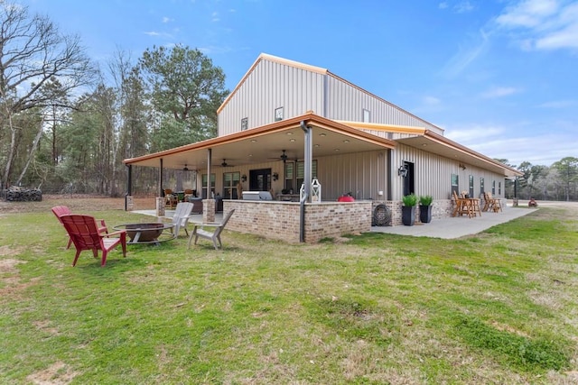 rear view of house with a patio area, an outdoor fire pit, a lawn, and a ceiling fan