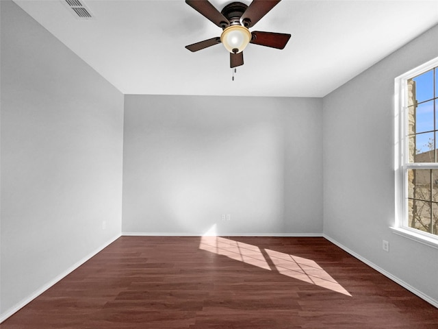 unfurnished room with baseboards, plenty of natural light, visible vents, and wood finished floors