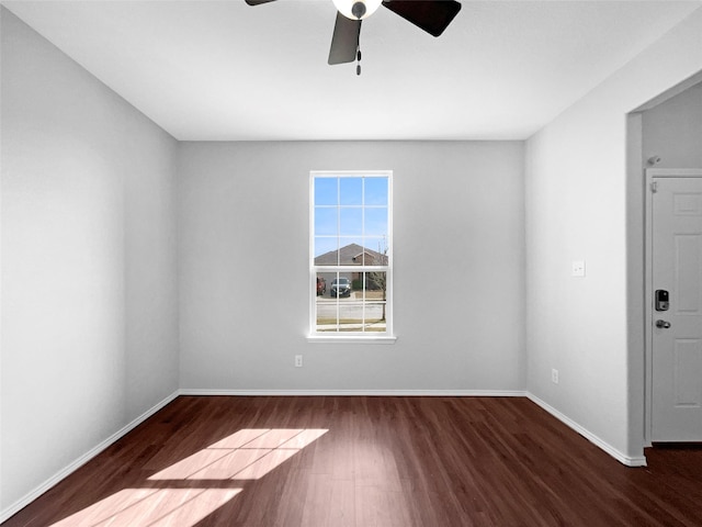 empty room featuring a ceiling fan, baseboards, and wood finished floors