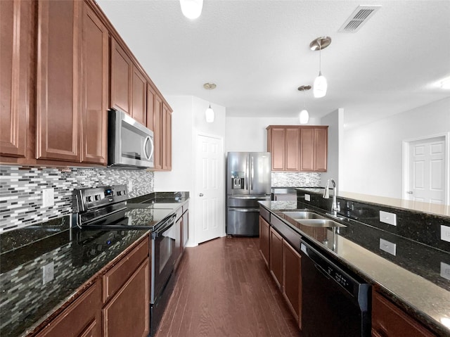 kitchen featuring visible vents, dark wood-style flooring, stainless steel appliances, pendant lighting, and a sink