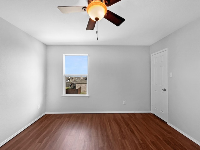 empty room with a ceiling fan, baseboards, and wood finished floors