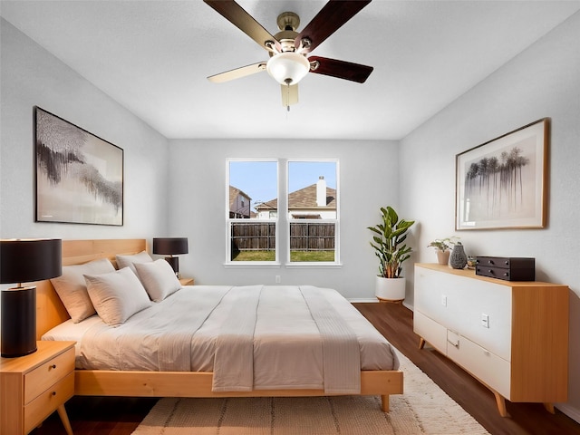 bedroom with ceiling fan, baseboards, and wood finished floors