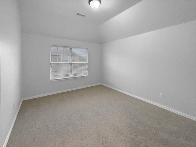 unfurnished room featuring lofted ceiling, carpet, visible vents, and baseboards