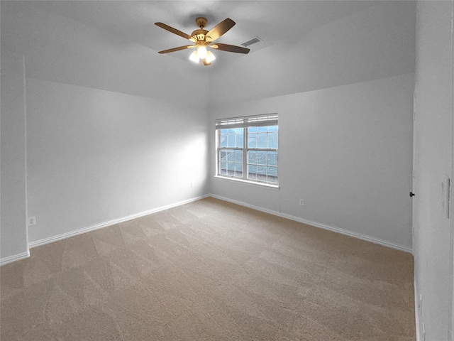 empty room with a ceiling fan, lofted ceiling, carpet, and baseboards