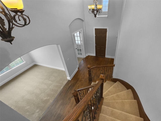 foyer entrance with a healthy amount of sunlight, baseboards, arched walkways, and wood finished floors