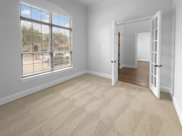 unfurnished room featuring french doors, carpet flooring, and baseboards