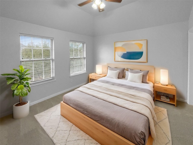 carpeted bedroom with a ceiling fan, vaulted ceiling, and baseboards