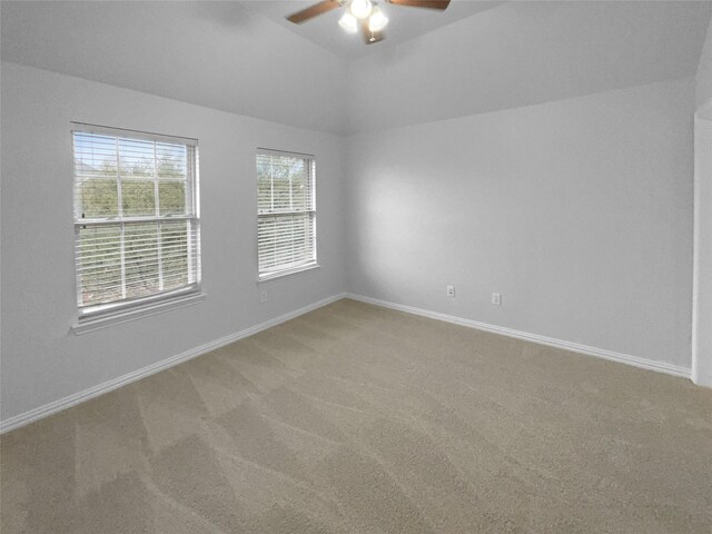 unfurnished room featuring ceiling fan, carpet, baseboards, and vaulted ceiling