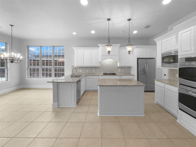 kitchen featuring light tile patterned floors, tasteful backsplash, a peninsula, stainless steel appliances, and a sink