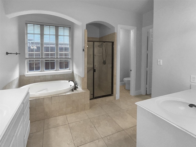 bathroom featuring toilet, a stall shower, vanity, a bath, and tile patterned floors