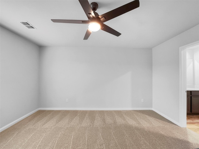 spare room featuring light carpet, baseboards, visible vents, and a ceiling fan