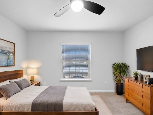 bedroom featuring light carpet, ceiling fan, and baseboards