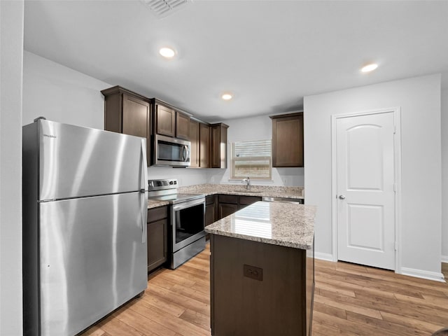 kitchen featuring visible vents, dark brown cabinets, appliances with stainless steel finishes, and light wood-style flooring