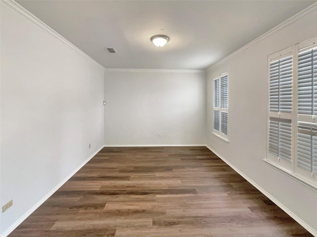 empty room featuring crown molding, baseboards, and wood finished floors