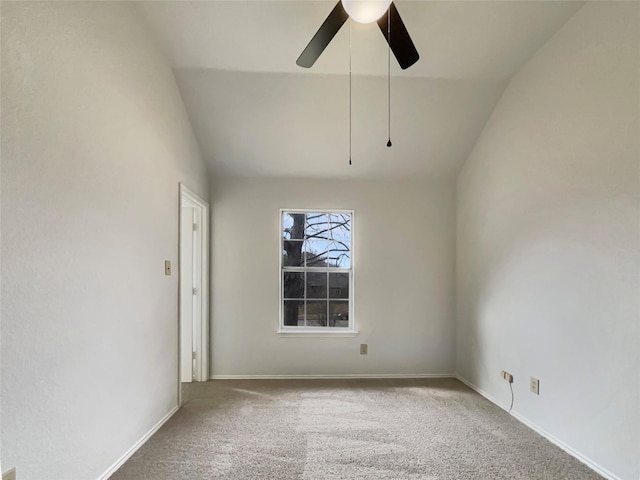 spare room featuring carpet floors, vaulted ceiling, baseboards, and a ceiling fan