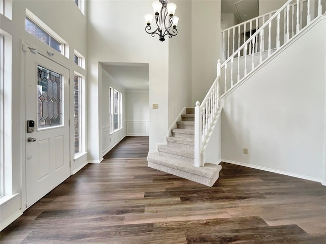 entrance foyer with a wealth of natural light, stairs, and dark wood-type flooring