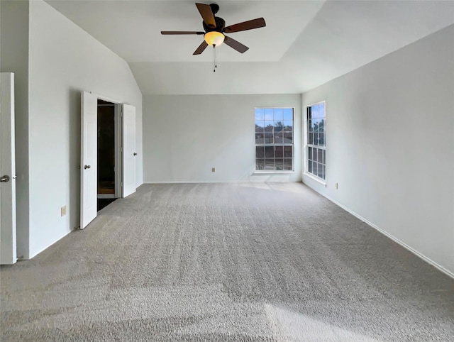 spare room featuring a ceiling fan, carpet flooring, vaulted ceiling, and baseboards