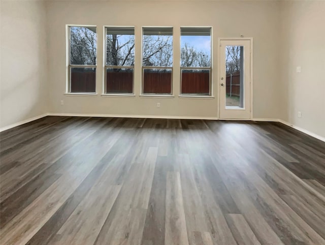 spare room featuring wood finished floors and baseboards