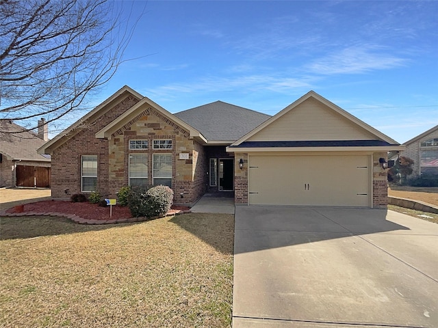 view of front facade featuring brick siding, a shingled roof, an attached garage, driveway, and a front lawn