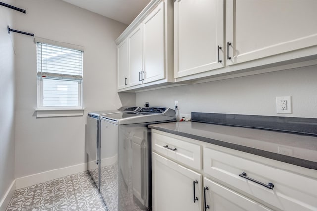 clothes washing area featuring washing machine and clothes dryer, cabinet space, baseboards, and light tile patterned flooring