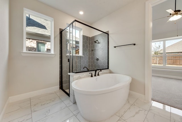 bathroom featuring marble finish floor, recessed lighting, a shower stall, a freestanding tub, and baseboards