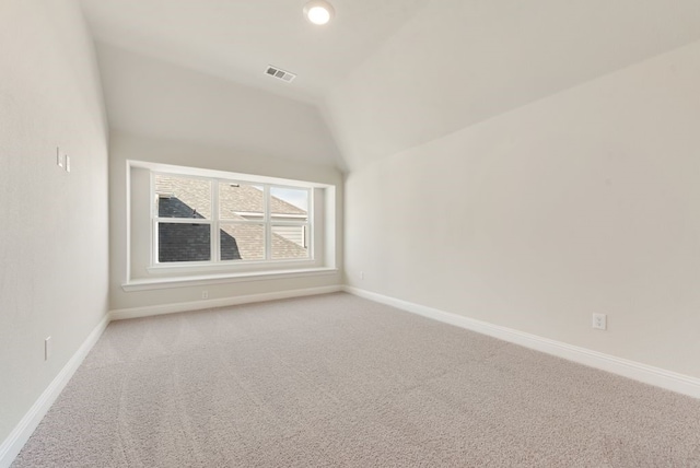 interior space with carpet, visible vents, baseboards, and vaulted ceiling