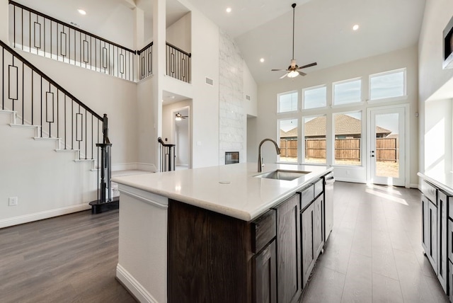 kitchen with dark wood finished floors, light countertops, a sink, ceiling fan, and dishwasher