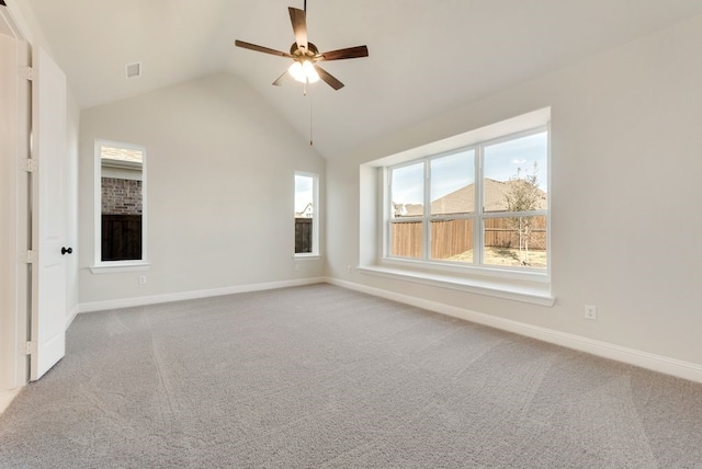 carpeted empty room with lofted ceiling, ceiling fan, visible vents, and baseboards