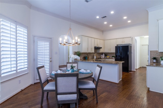 dining area with dark wood-style floors, a notable chandelier, recessed lighting, visible vents, and ornamental molding