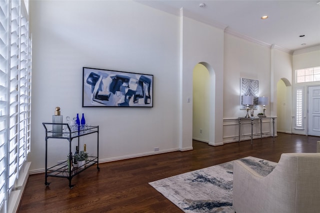 foyer entrance with arched walkways, recessed lighting, wood finished floors, baseboards, and crown molding