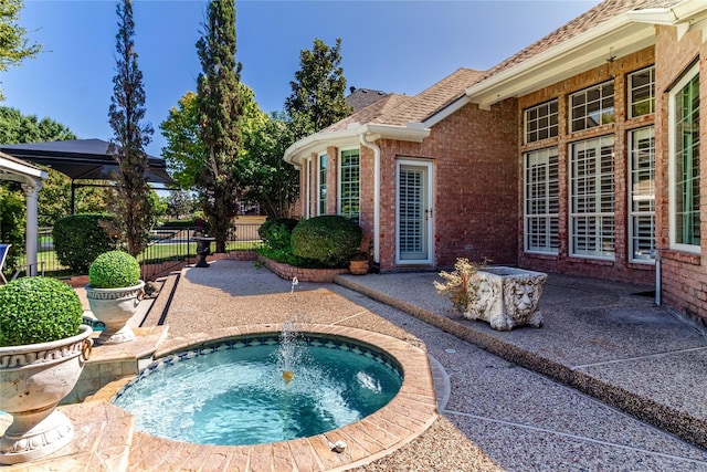 view of pool with a patio, fence, and an outdoor hot tub