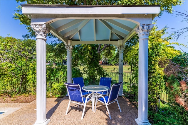 view of patio featuring a gazebo, fence, and outdoor dining space