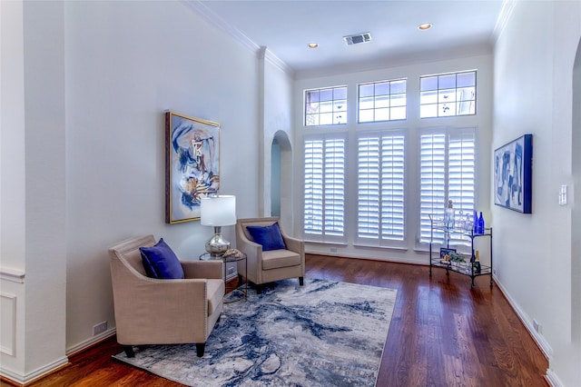 living area featuring recessed lighting, wood finished floors, visible vents, baseboards, and crown molding