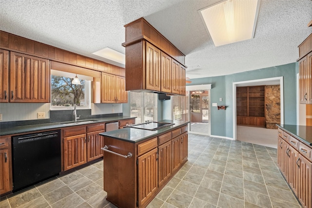 kitchen featuring dark countertops, black appliances, a textured ceiling, and a sink