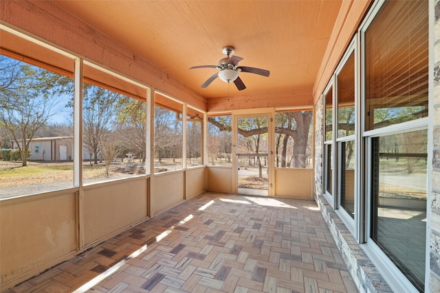 unfurnished sunroom featuring ceiling fan