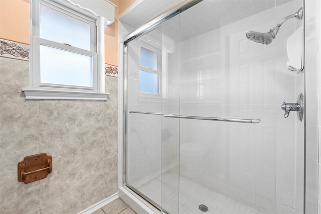 full bath featuring tile patterned flooring and a shower stall